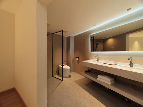 y baño con lavabo y espejo. en XILU INN muxin, en Lijiang