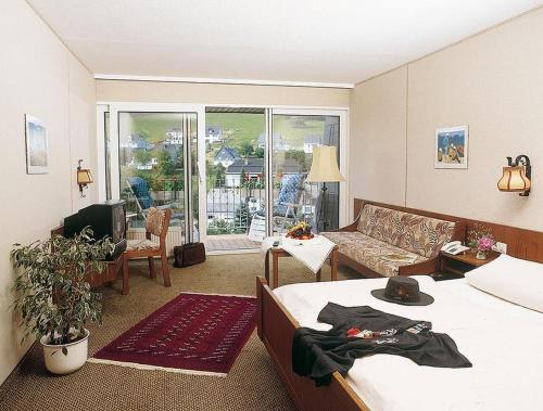um quarto com 2 camas e uma sala de estar com um sofá em Gasthof Heimes em Schmallenberg