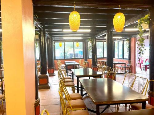 a restaurant with tables and chairs and yellow lights at Woodstock Beach Camp in Cat Ba