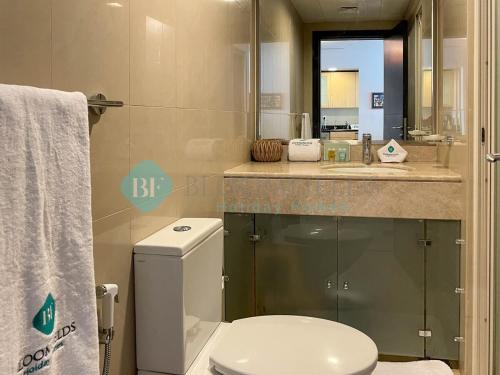 een badkamer met een wit toilet en een wastafel bij Spacious 1 Bedroom In Sun Tower in Abu Dhabi