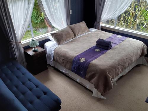 a bed sitting in a room with a window at Terracotta Cottage in Te Awamutu