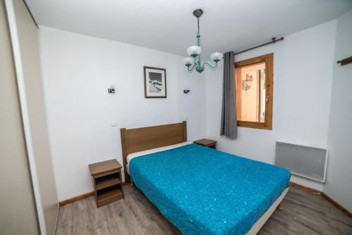 ein Schlafzimmer mit einem Bett mit einer blauen Decke in der Unterkunft Appartement Vars in Vars