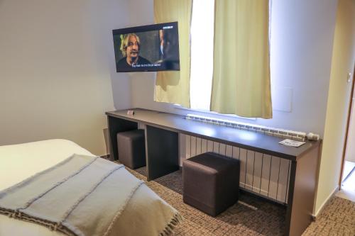 a bedroom with a desk with a tv on a window at Studio Apartments Visit Point in Sarajevo