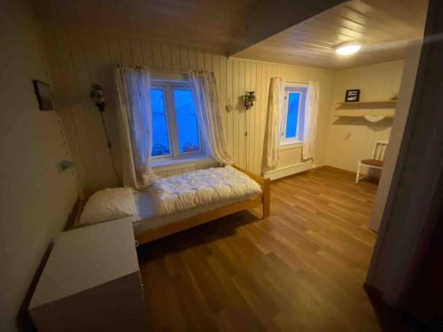 een kleine kamer met een bed en een raam bij Hus i Lofoten in Laupstad