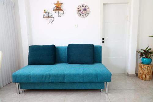 a blue couch sitting in a living room at דירה יפה סגנון מודרני מרחק של 5 דקות נסיעה מהים in Ashqelon
