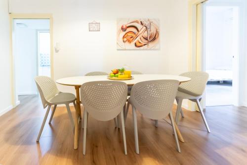 Ziv Apartments - Gottlieb 4 في تل أبيب: غرفة طعام مع طاولة بيضاء وكراسي