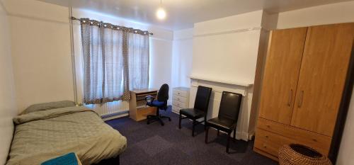 a bedroom with a bed and a desk and a television at Marina House in Ipswich