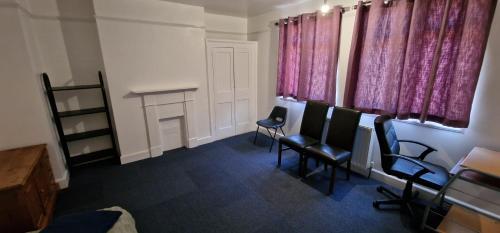 a waiting room with chairs and pink curtains at Marina House in Ipswich