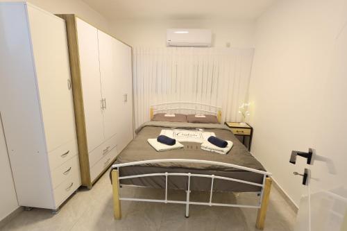 a small bedroom with a bed and a closet at דירה יפה סגנון מודרני מרחק של 5 דקות נסיעה מהים in Ashqelon