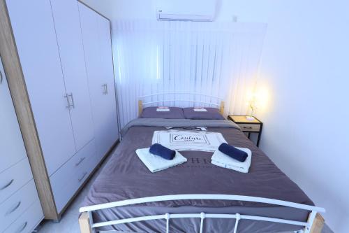 1 dormitorio con 1 cama con 2 toallas en דירה יפה סגנון מודרני מרחק של 5 דקות נסיעה מהים, en Ashkelon