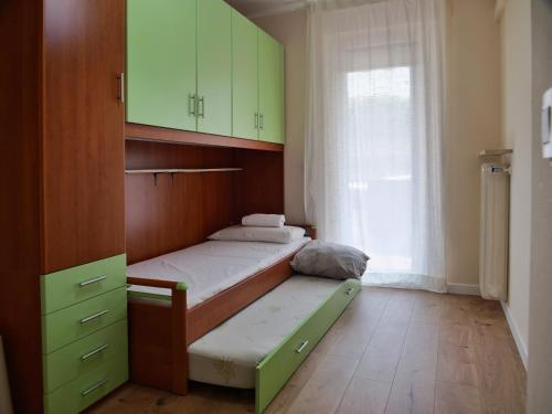una camera da letto con un letto con armadi verdi e una finestra di Contrada Cappello - Tricamere centralissimo a Palmanova