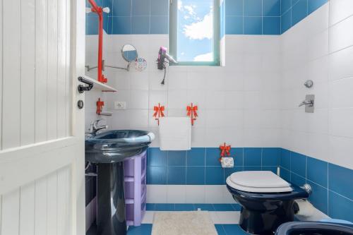 a blue and white bathroom with a toilet and a sink at Isulidda Gaia Mare in San Vito lo Capo