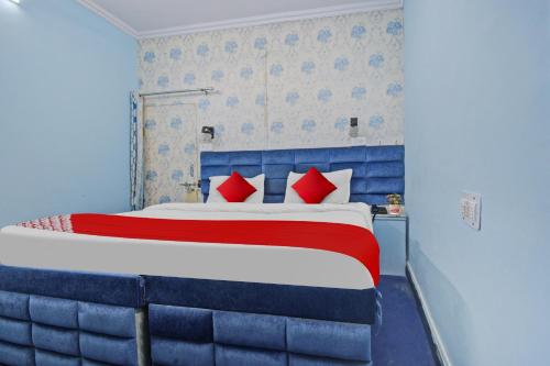 a bedroom with a bed with blue and red pillows at OYO Flagship Meenu Inn in Jaipur