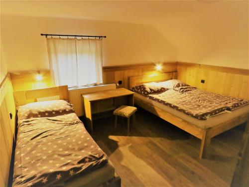 1 Schlafzimmer mit 2 Betten, einem Tisch und einem Fenster in der Unterkunft Bouda Na Pláni - horská bouda in Špindlerův Mlýn