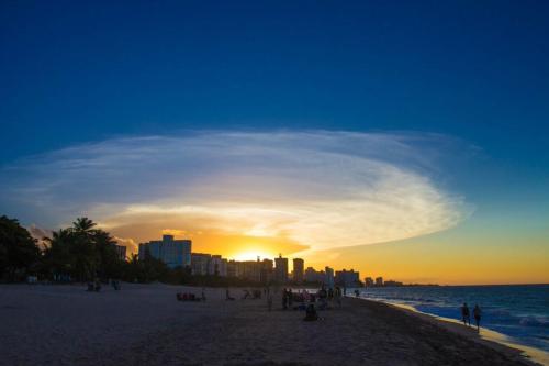 a group of people on a beach at sunset at Dream Inn PR in San Juan