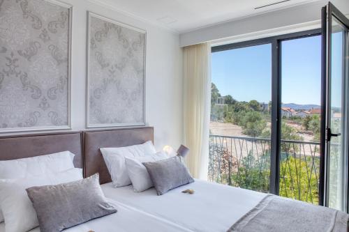 Un dormitorio con dos camas y una gran ventana. en Spuga, en Brodarica