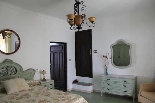 a bedroom with a bed and a dresser and a mirror at Casa Alcaida in Quesada