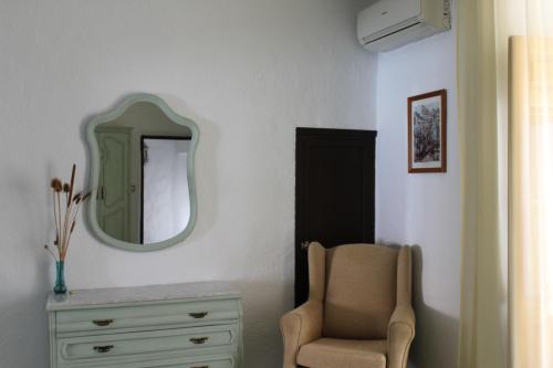 a bedroom with a dresser and a mirror and a chair at Casa Alcaida in Quesada