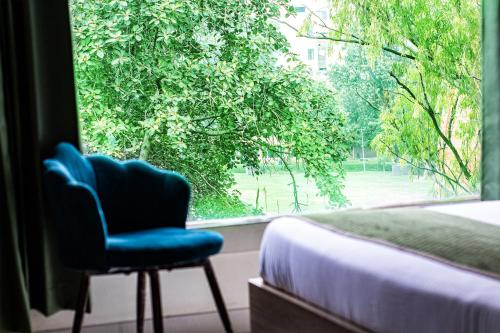 a bedroom with a blue chair and a window at Hotel Global Inn in Amritsar