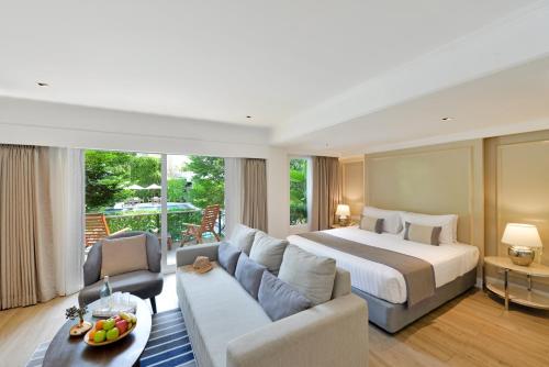 a bedroom with a bed and a living room at The Beverly Hotel Pattaya in Pattaya South