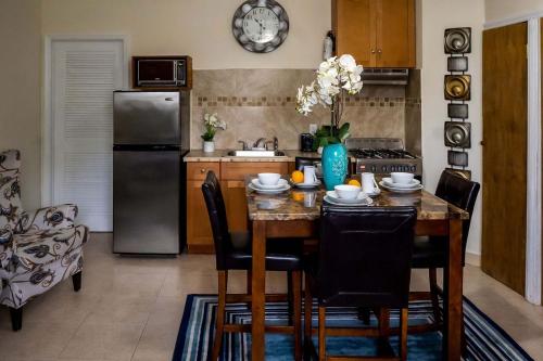 ナッソーにあるA Taste of Paradise - Vacation Rentals close to US Embassy & Restaurantsのテーブルと椅子、冷蔵庫のあるキッチン
