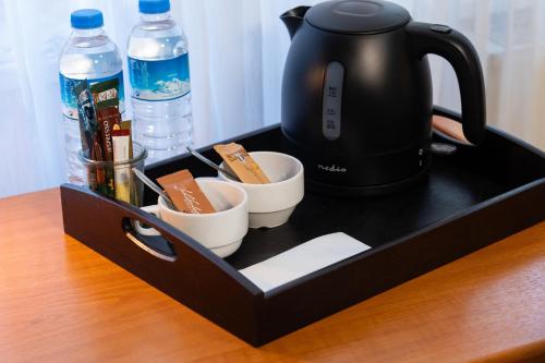 a tray with a tea kettle and cups on a table at Landhotel Elkemann in Ahaus