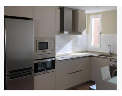eine Küche mit einem Backofen und Geräten aus Edelstahl in der Unterkunft Apartamento céntrico de diseño en calle Tres Forques,Valencia in Valencia