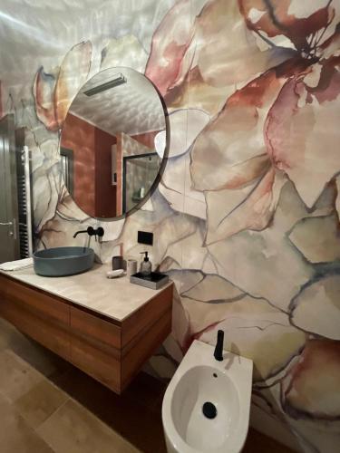 y baño con lavabo, espejo y aseo. en Langhetta's house - Alta Langa, en Murazzano