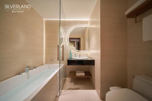 a bathroom with a tub and a sink and a toilet at Silverland Bến Thành in Ho Chi Minh City