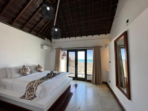 MontongbuwohにあるVilla Pantaiのベッドと大きな窓のある寝室