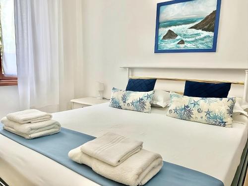 a bedroom with a large bed with towels on it at Ca del Mare - FREE Parking in La Spezia