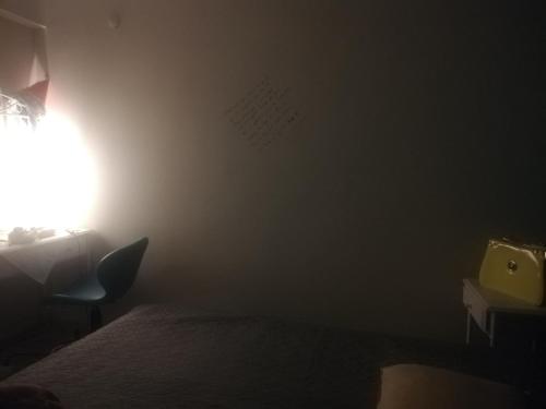 1 dormitorio con 1 cama y una luz en la pared en ewwren, en Konak
