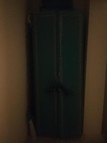 una puerta verde en la esquina de una habitación en ewwren, en Konak