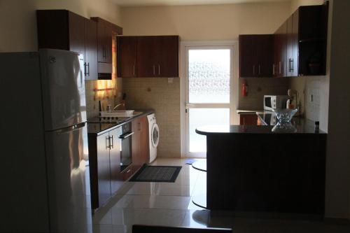 a kitchen with a refrigerator and a dishwasher at Maricosta Villas in Protaras