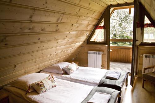 1 dormitorio con 1 cama en una cabaña de madera en Zakońpiańska Chata - Domek Góralski Na Kamieńcu, en Zakopane