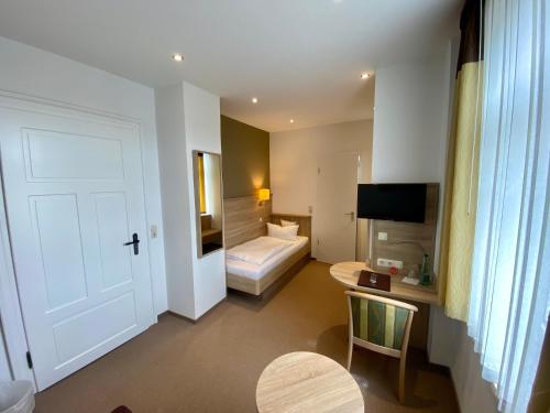 a hotel room with a bedroom with a bed and a door at Gasthof Drei Schwanen in Langenwetzendorf