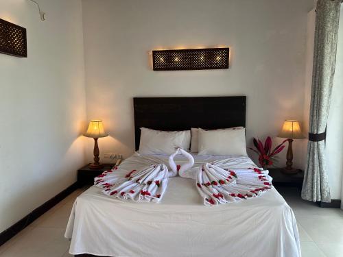 a bedroom with a bed with white sheets and pillows at Amaluna Resorts in Negombo