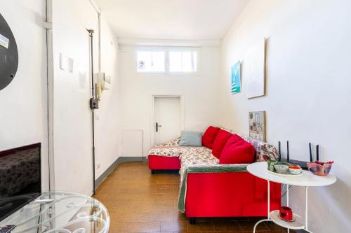 Alfani 63 Apartment في فلورنسا: غرفة معيشة مع أريكة حمراء وطاولة