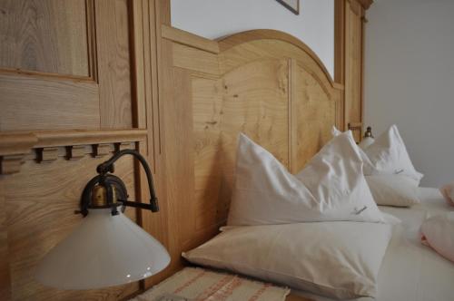 a lamp on a bed with white pillows at B&B - Apartments Sunnwies in Marlengo