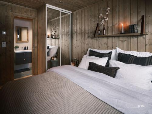 a bedroom with a large white bed with wooden walls at Beautiful apartment - high standard - Geilo centre in Geilo