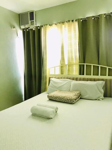 卡加延德奧羅的住宿－Primavera Residence Silver 3Kates，床上有2个枕头