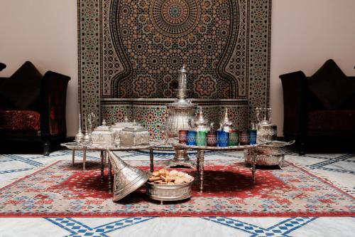 a living room with two tables and a rug at Riad Dar Laura in Fez