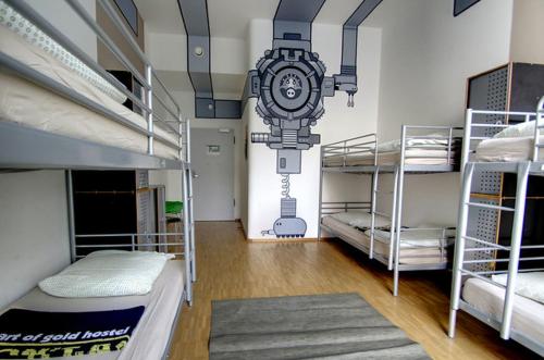 a room with three bunk beds and a clock on the wall at Heart of Gold Hostel Berlin in Berlin