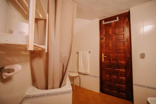 ベナオカスにあるLos Chozosのバスルーム(トイレ付)、木製のドアが備わります。