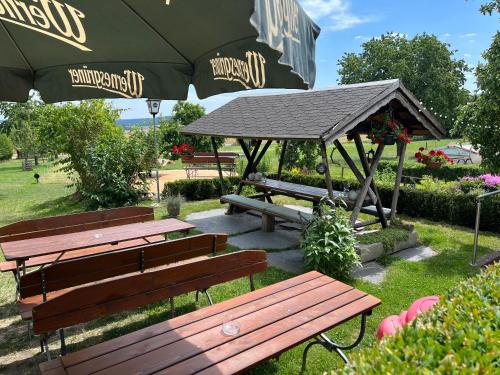 a picnic area with benches and an umbrella at Gasthof Drei Schwanen in Langenwetzendorf