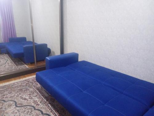a blue couch in a room with a mirror at NIZAMI Street flat in Baku