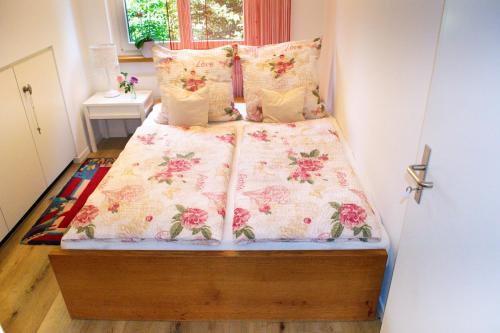 Waldparadies in Neftenbach I Winterthur Nummer 1 في Neftenbach: غرفة نوم مع سرير مع زهور وردية عليه