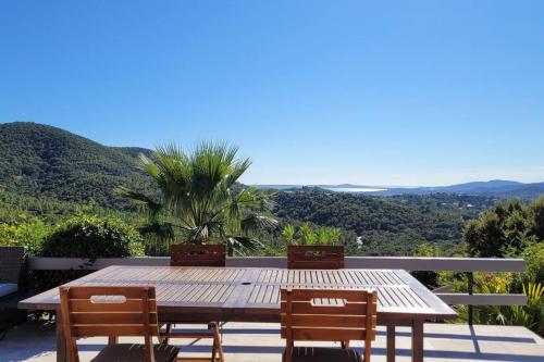 - une table et des chaises en bois sur une terrasse avec vue dans l'établissement Natural Beauty - View of Les Maures and the Sea, à La Londe-les-Maures