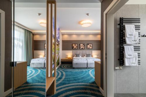 a hotel room with two beds and a corridor at Hotel Kőporos Hercegkút in Hercegkút