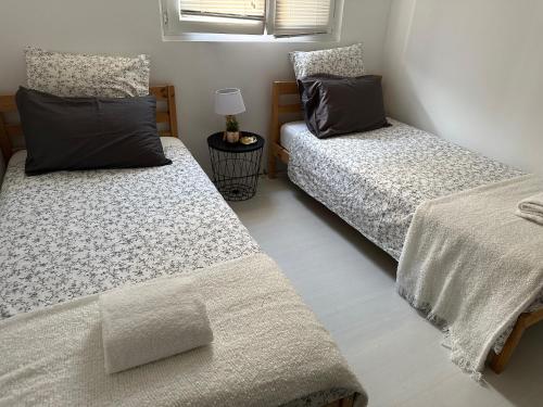 a bedroom with two beds and a table with a lamp at Privât Room In private residence with free parking, 1 minute from tramway, 9 minutes from de center, accessible all transports in Nice